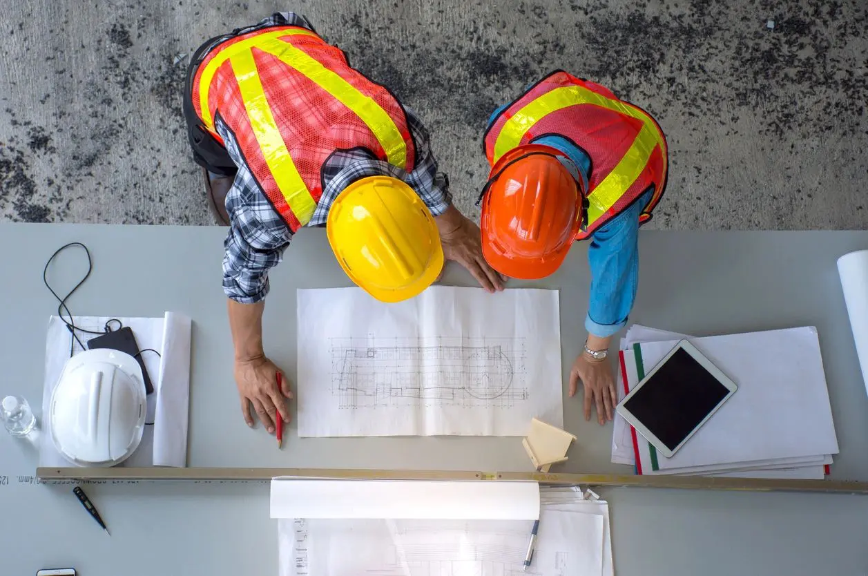 Two construction workers looking over a plan